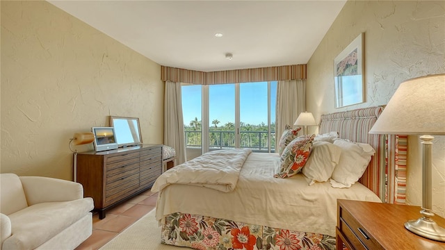 bedroom featuring light tile patterned floors and a textured wall