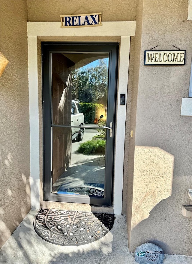 property entrance with stucco siding