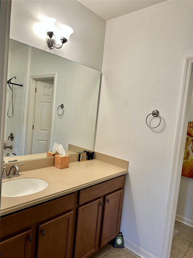 bathroom with tile patterned flooring, a textured ceiling, vanity, and baseboards