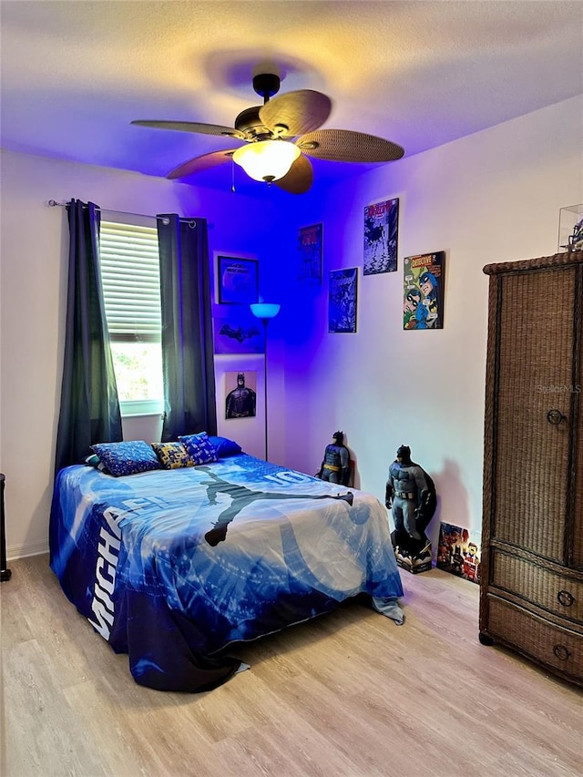 bedroom featuring ceiling fan, a textured ceiling, and wood finished floors