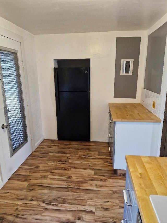 775 36th Ave S, Saint Petersburg, FL 33705 - kitchen featuring wood finished floors, wood counters, freestanding refrigerator, and decorative backsplash