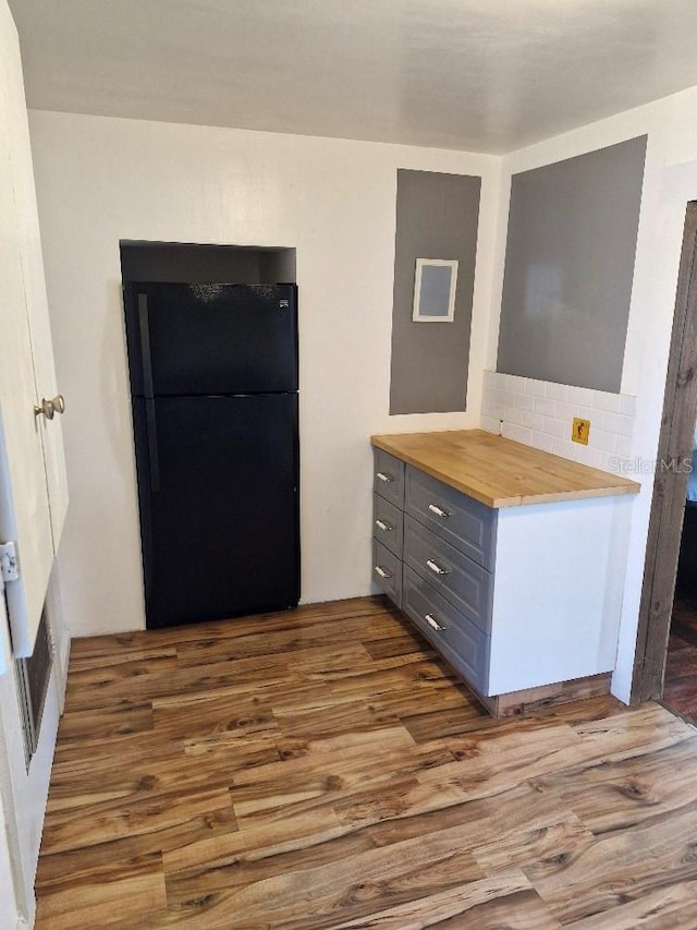 775 36th Ave S, Saint Petersburg, FL 33705 - kitchen with wood finished floors, freestanding refrigerator, gray cabinetry, wooden counters, and backsplash