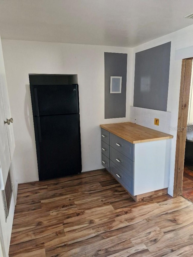 775 36th Ave S, Saint Petersburg, FL 33705 - kitchen featuring dark wood finished floors, decorative backsplash, gray cabinetry, freestanding refrigerator, and wood counters