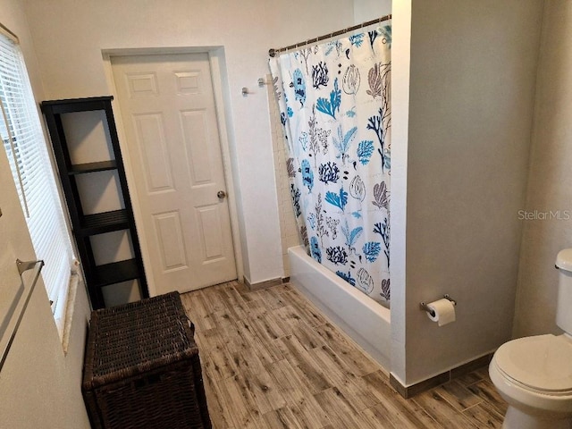 775 36th Ave S, Saint Petersburg, FL 33705 - bathroom featuring baseboards, wood finished floors, toilet, and shower / bathtub combination with curtain