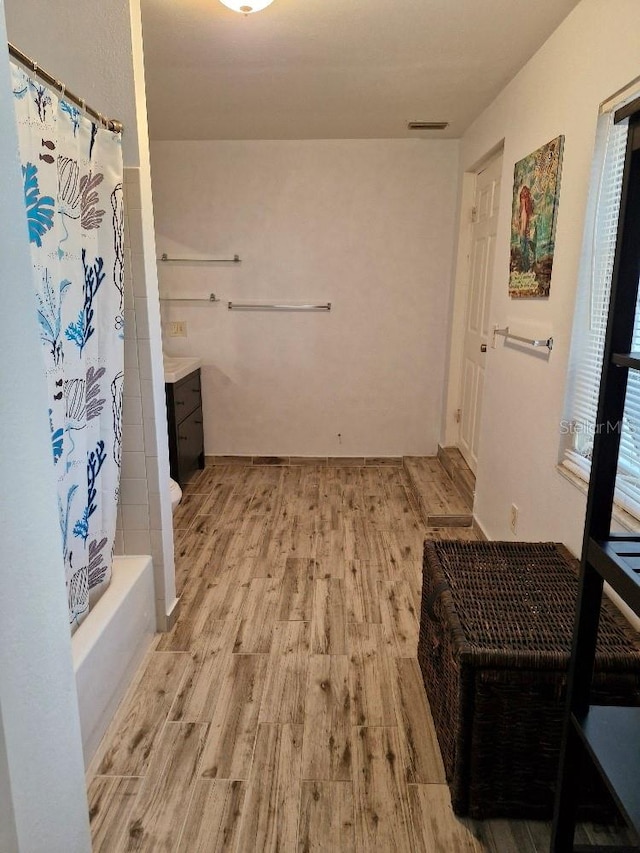 775 36th Ave S, Saint Petersburg, FL 33705 - interior space featuring shower / bath combination with curtain, visible vents, wood finished floors, and vanity