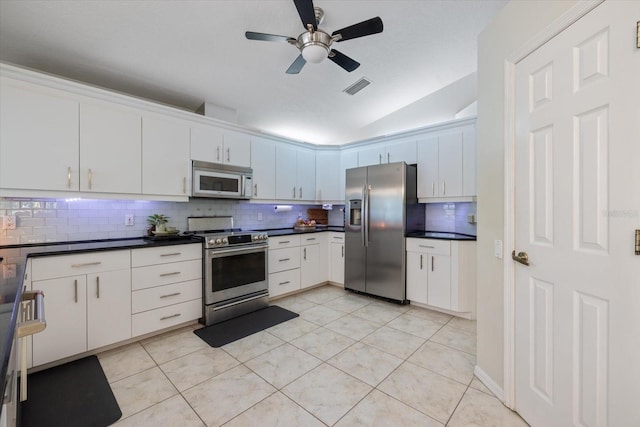 kitchen featuring light tile patterned floors, tasteful backsplash, visible vents, dark countertops, and stainless steel appliances