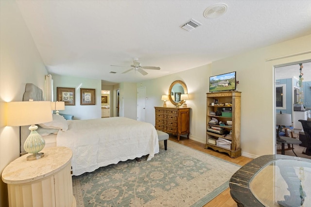 bedroom with baseboards, light wood-style flooring, visible vents, and a ceiling fan