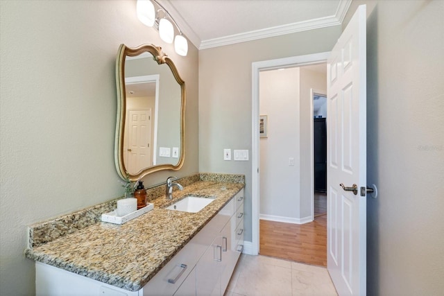 bathroom featuring baseboards, ornamental molding, and vanity