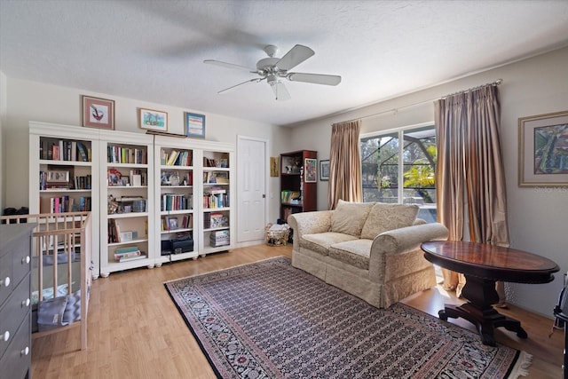 sitting room featuring a textured ceiling, a ceiling fan, and wood finished floors