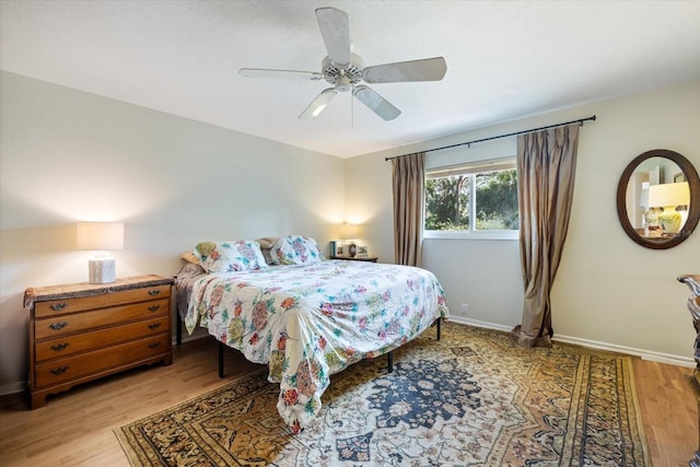 bedroom with ceiling fan, light wood-type flooring, and baseboards