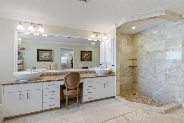 bathroom featuring a textured ceiling, ornamental molding, walk in shower, and vanity