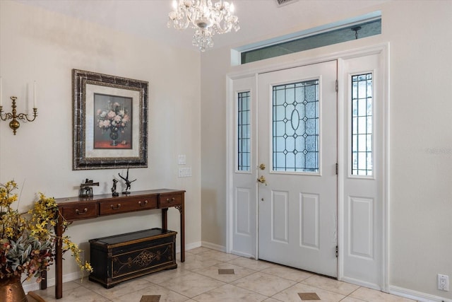 foyer featuring baseboards, light tile patterned flooring, and an inviting chandelier