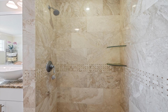 details featuring ornamental molding, a tile shower, and vanity