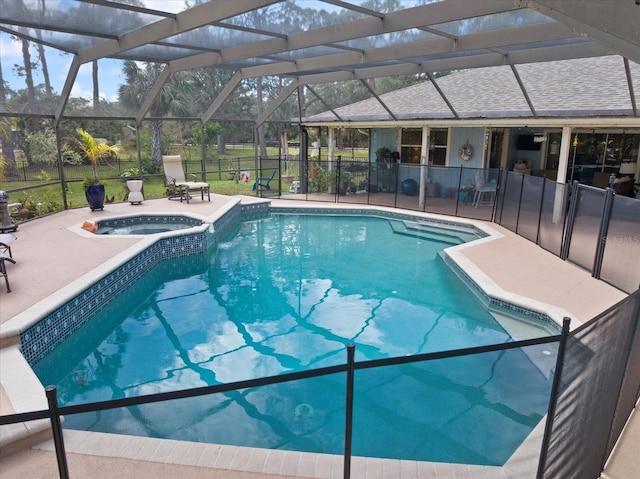 view of swimming pool featuring a patio area, a pool with connected hot tub, and glass enclosure