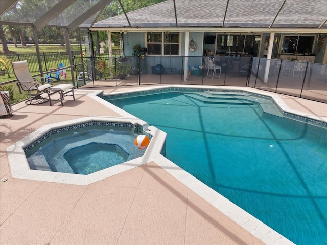 view of swimming pool with a lanai, a patio area, a pool with connected hot tub, and fence