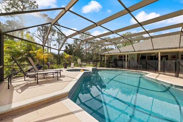 view of pool featuring a pool with connected hot tub, a lanai, and a patio