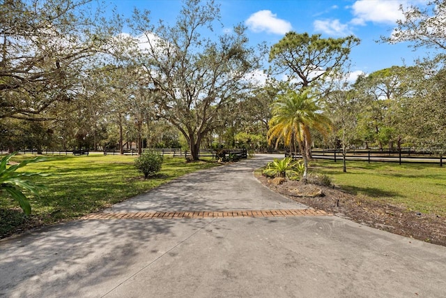 view of home's community with a yard and fence