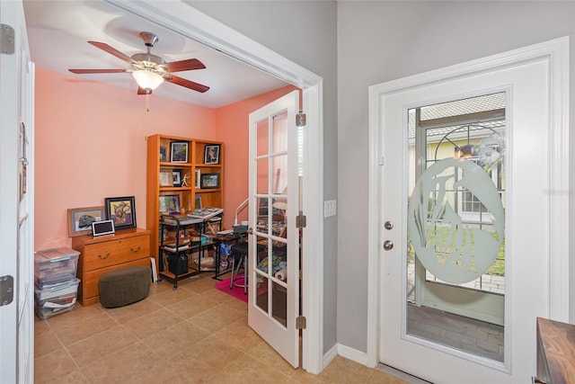 entryway featuring ceiling fan, light tile patterned flooring, and baseboards