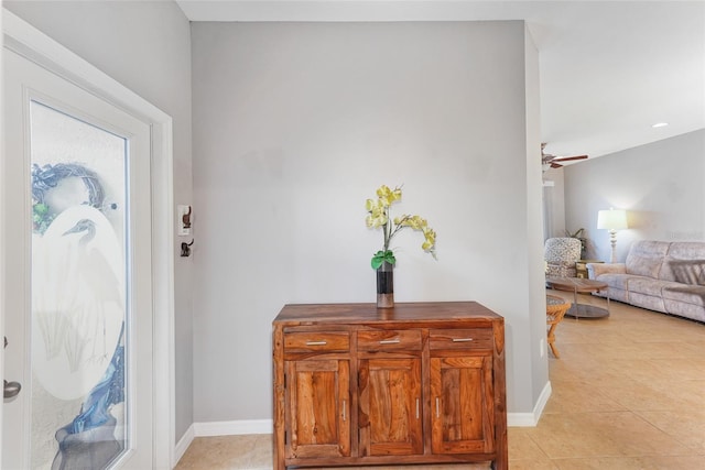 foyer with a ceiling fan, light tile patterned flooring, and baseboards