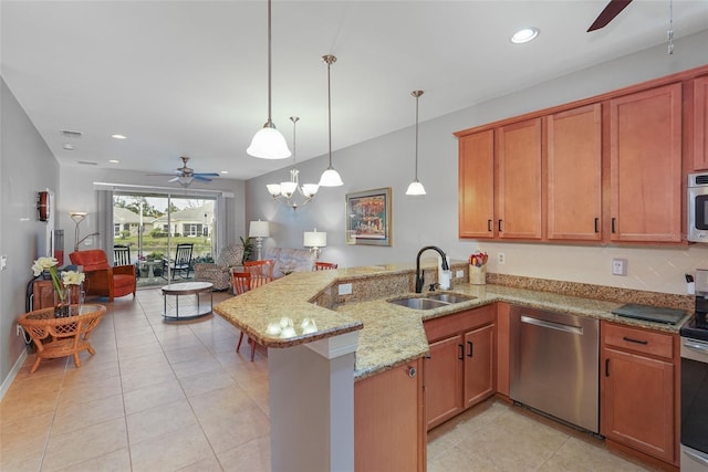 kitchen with ceiling fan, appliances with stainless steel finishes, light stone counters, a peninsula, and a sink