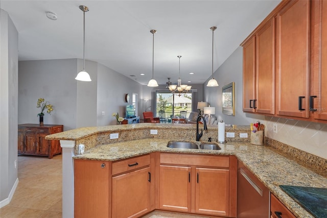 kitchen with black electric stovetop, light stone counters, a peninsula, a sink, and decorative light fixtures