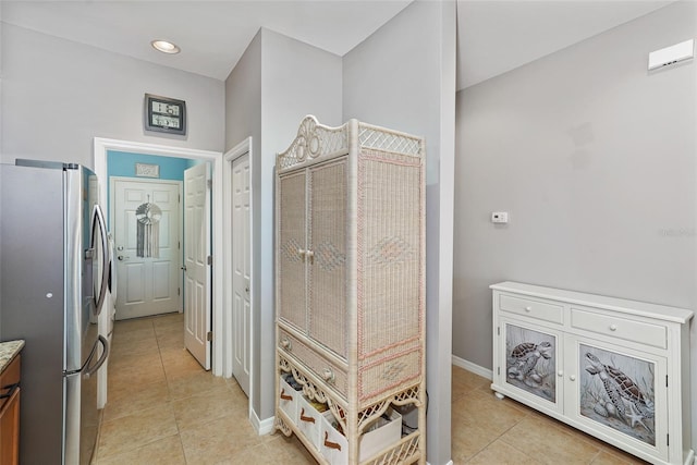 hallway featuring light tile patterned floors and baseboards