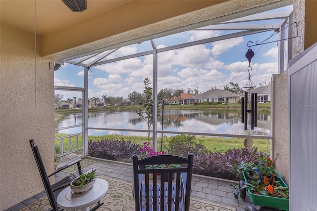 sunroom with a water view and a residential view