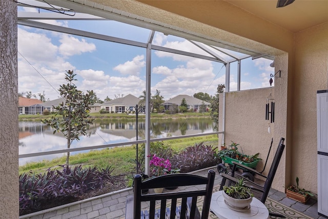 sunroom featuring a water view