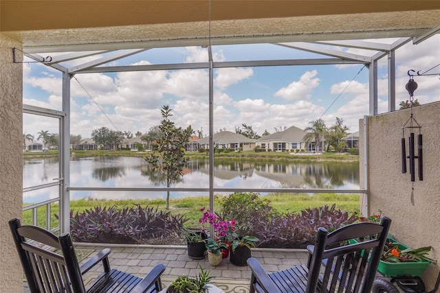 sunroom with a water view and a residential view