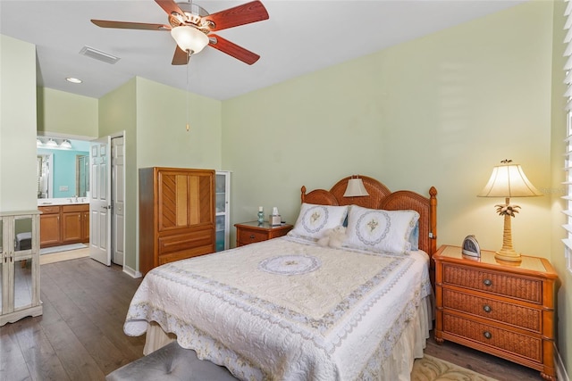 bedroom with dark wood-style floors, ceiling fan, visible vents, and ensuite bathroom