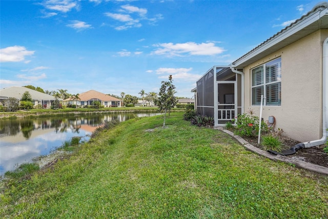 view of yard with a water view and a lanai