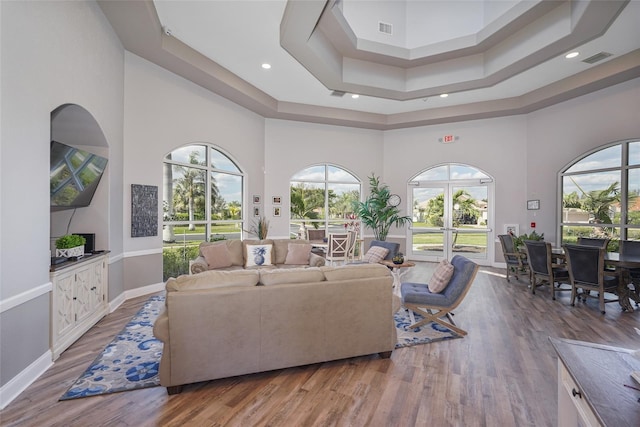 living room featuring visible vents, a high ceiling, and wood finished floors