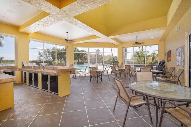 sunroom featuring ceiling fan, coffered ceiling, and beam ceiling