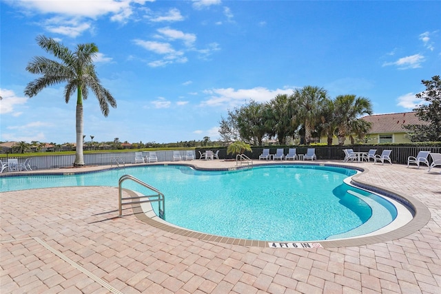 pool with a patio and fence