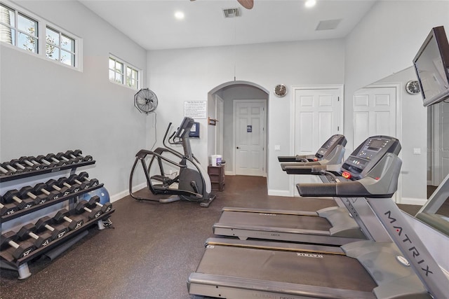 gym with arched walkways, recessed lighting, visible vents, and baseboards