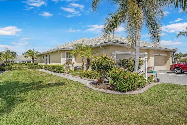 view of side of home with an attached garage, a tile roof, driveway, a lawn, and stucco siding