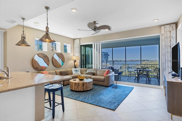 living room featuring light tile patterned floors, ceiling fan, and visible vents