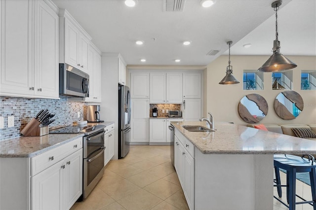 kitchen featuring stainless steel appliances, light tile patterned flooring, visible vents, and white cabinets