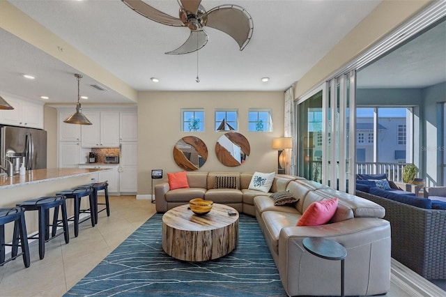 living area featuring ceiling fan, light tile patterned flooring, recessed lighting, visible vents, and baseboards