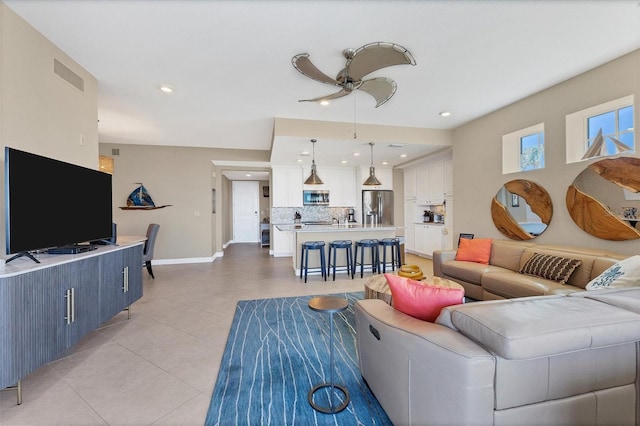 living area with light tile patterned floors, baseboards, visible vents, a ceiling fan, and recessed lighting