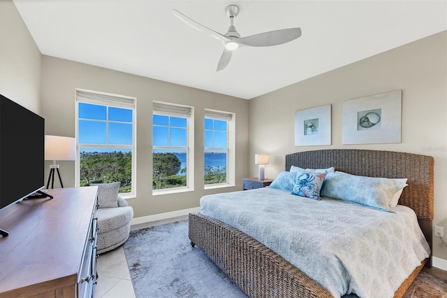 bedroom featuring ceiling fan, tile patterned flooring, and baseboards