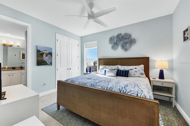 bedroom with a closet, connected bathroom, a ceiling fan, and baseboards