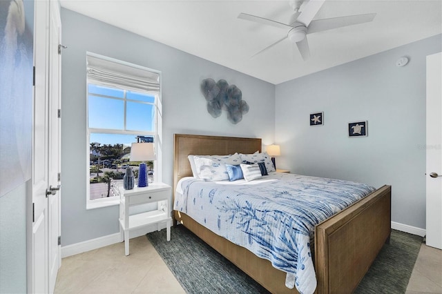 bedroom featuring ceiling fan, tile patterned flooring, and baseboards