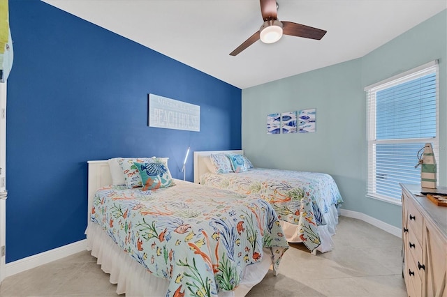 tiled bedroom with ceiling fan and baseboards