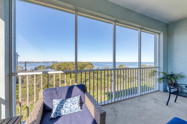 sunroom featuring a water view