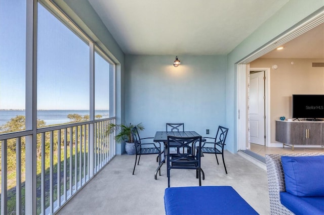 sunroom / solarium featuring a water view and plenty of natural light