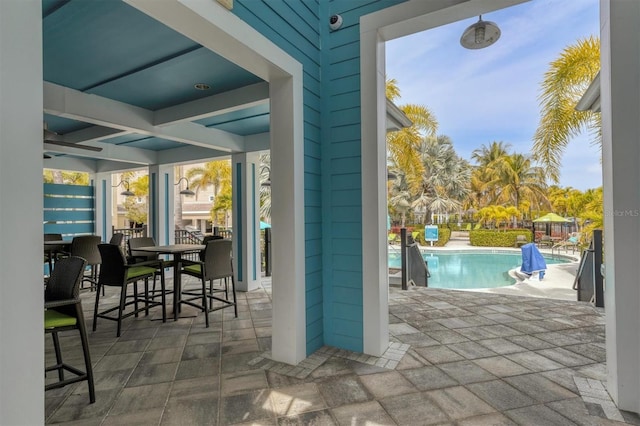 exterior space with outdoor dining space and an outdoor pool