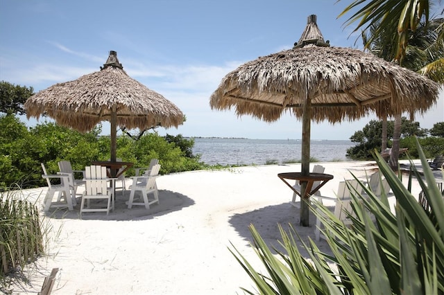 view of community with a water view, a patio area, outdoor dining space, and a gazebo