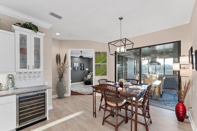 dining room featuring wine cooler, visible vents, light wood-style flooring, and baseboards