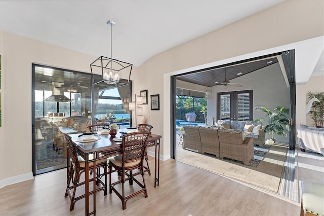 dining area featuring vaulted ceiling, wood finished floors, and a wealth of natural light